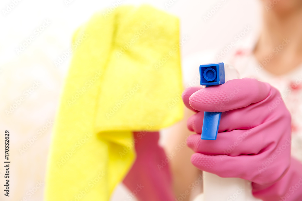 Hand in protective glove holding spray. Cleaning a kitchen concept Hand in protective glove holding spray. Cleaning a kitchen concept