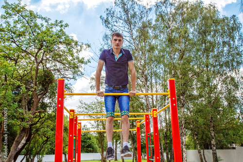 young man is practicing on a horizontal bar