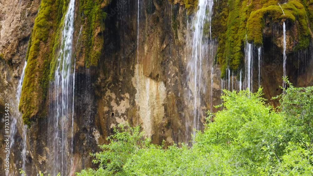 waterfall pouring down on stone rock wall. ecosystem nature environment background waterfall pouring down on stone rock wall. ecosystem nature environment background