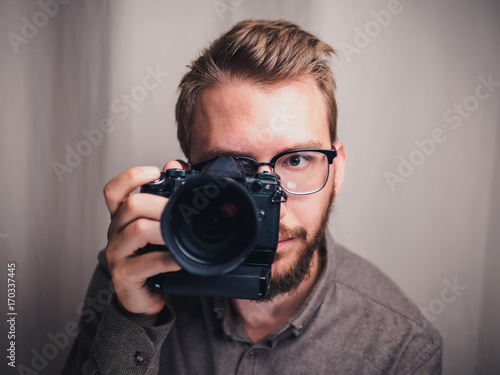 Male photographer with camera in arm