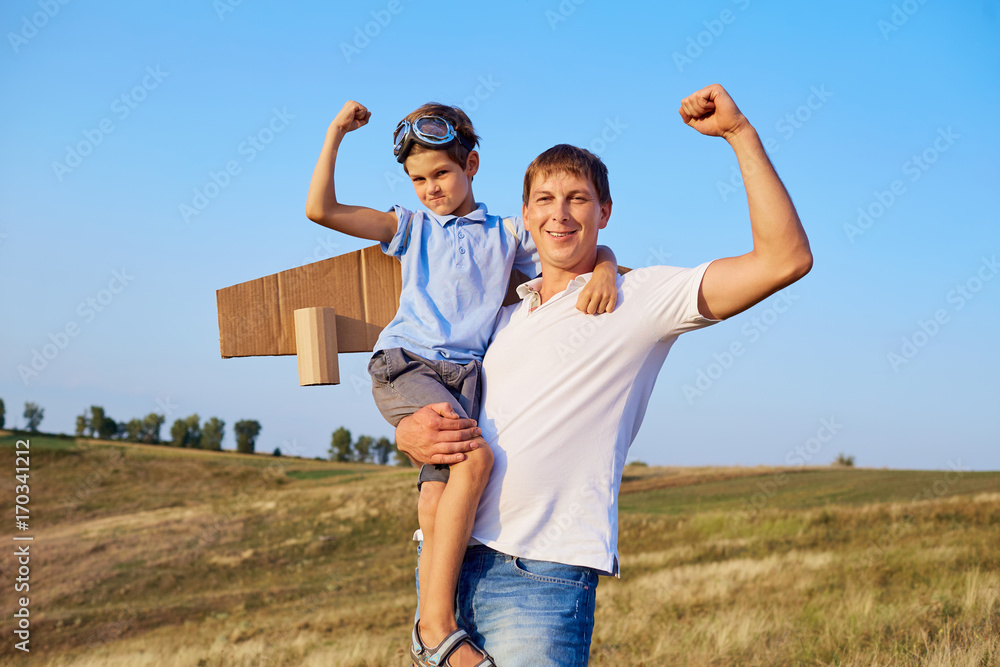Obraz premium Father and son show muscles in nature.Father's Day.