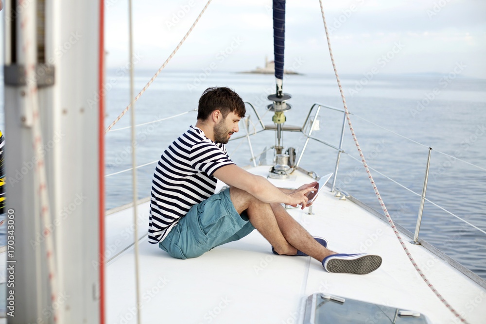 Man using digital tablet on sailboat, Adriatic Sea