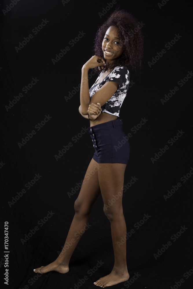 Pretty Black woman in shorts smiling with pleasure