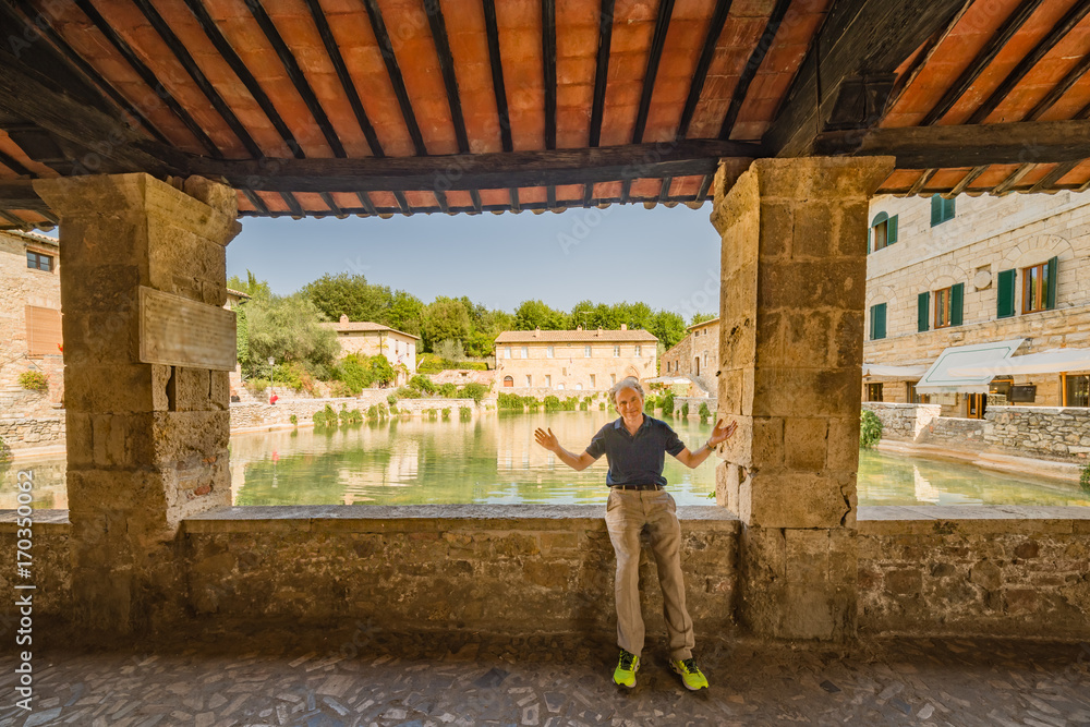 man with open arms on medieval public flooded square man with open arms on medieval public flooded square