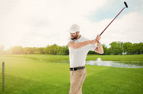 Young man playing golf on course