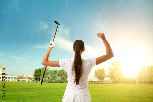 Young woman playing golf on course