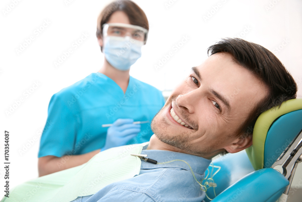 Handsome man at dentist's office in clinic Handsome man at dentist's office in clinic