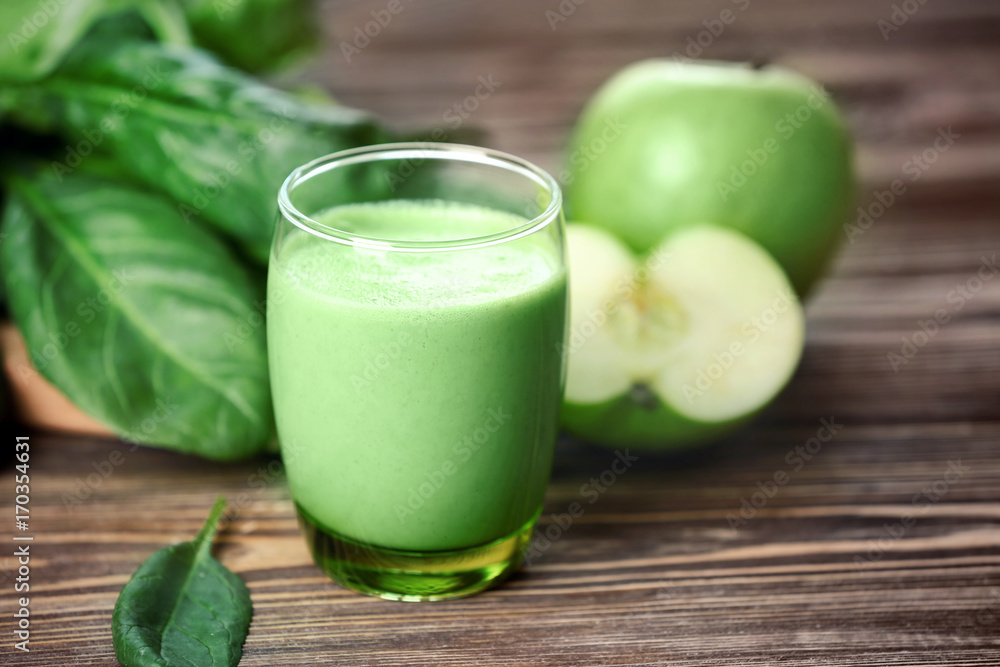 Glass of green healthy juice with ingredients on wooden table Glass of green healthy juice with ingredients on wooden table