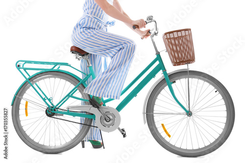 Beautiful young woman riding bicycle on white background