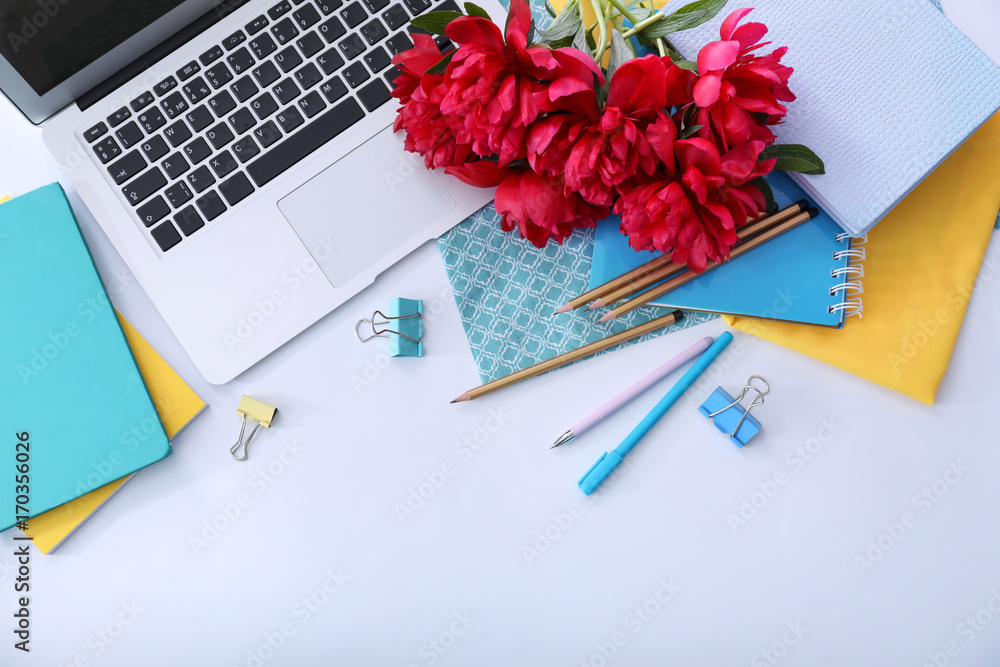 Bouquet of beautiful peony flowers, laptop and stationery on light table Bouquet of beautiful peony flowers, laptop and stationery on light table
