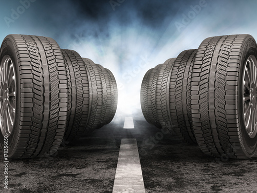 Car tires standing on the road against light of headlights. photo