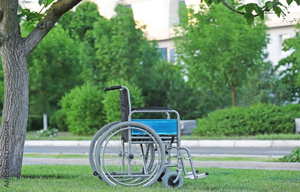 Fototapeta premium Wheelchair in green park. Elderly care concept