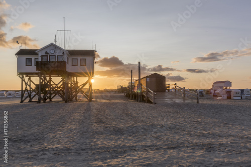Wooden house on stilts on the beach at sunrise