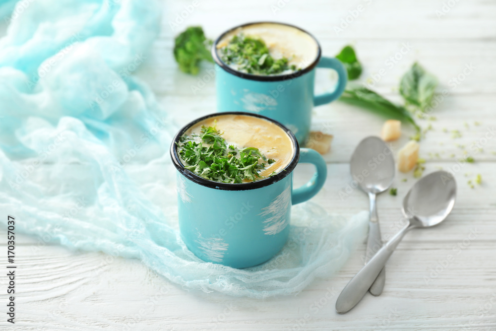 Cups with broccoli cheddar soup on table Cups with broccoli cheddar soup on table