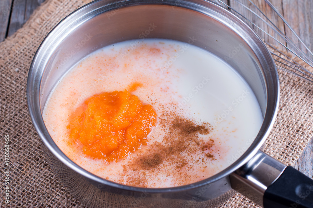 Preparation of pumpkin latte. Milk, pumpkin puree and spices in a saucepan Preparation of pumpkin latte. Milk, pumpkin puree and spices in a saucepan