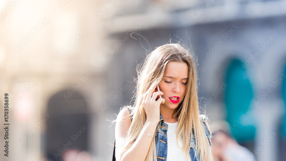 Pensive blonde teenager outdoor with her mobile phone Pensive blonde teenager outdoor with her mobile phone