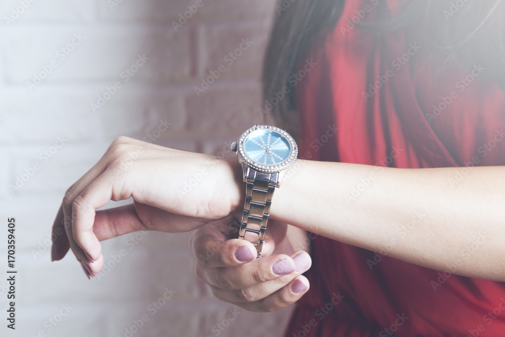 Female hands checking the time on a wristwatch Female hands checking the time on a wristwatch