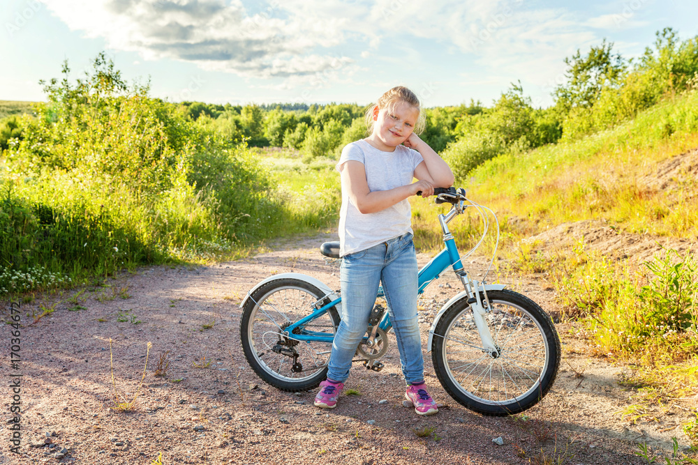 Obraz premium Smiling little girl on a bicycle