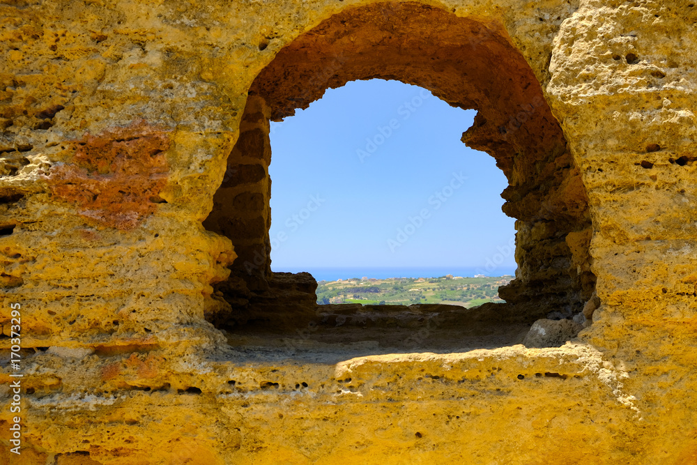 Looking through an ancient window to the distant sea