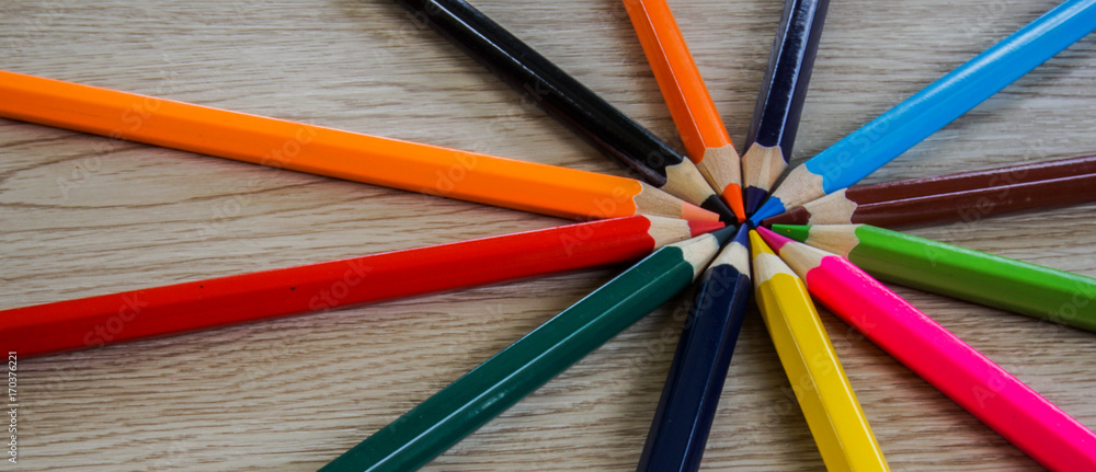 Fototapeta premium Color pencils and compass isolated on wooden background.Close up.