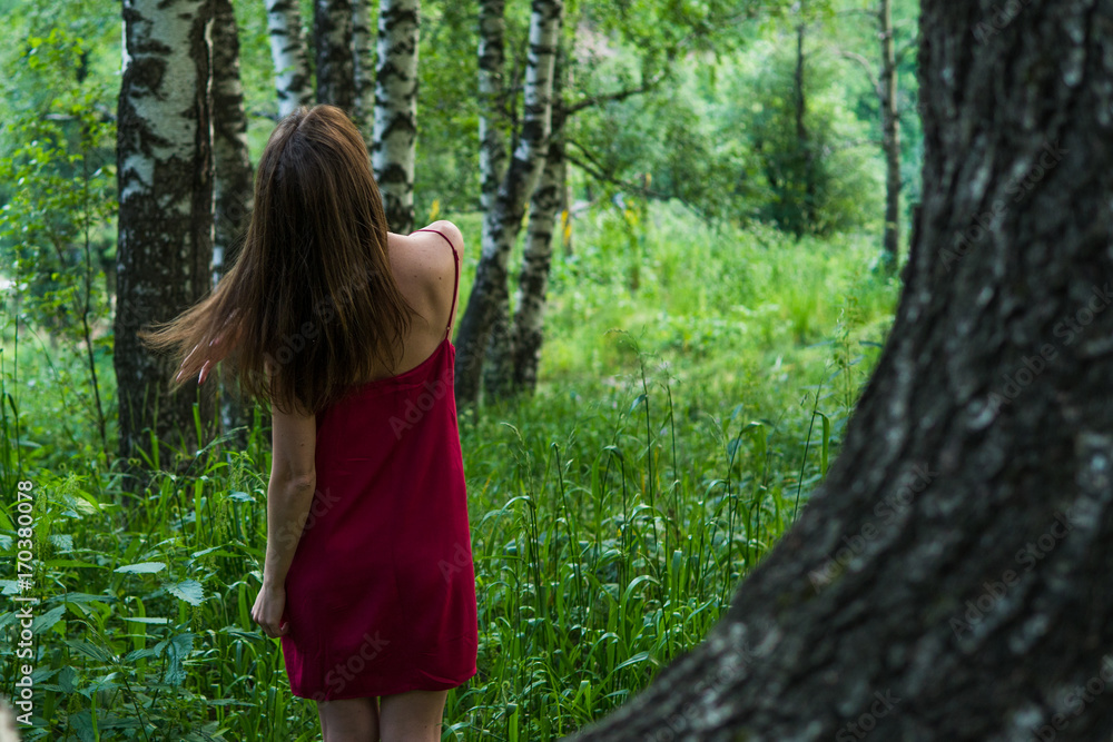 Pretty girl in red dress in a summer forest in the mountains Pretty girl in red dress in a summer forest in the mountains