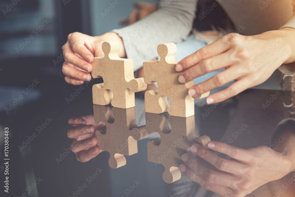 Closeup hand of woman connecting jigsaw puzzle with sunlight effect, Business solutions, success and strategy concept Closeup hand of woman connecting jigsaw puzzle with sunlight effect, Business solutions, success and strategy concept
