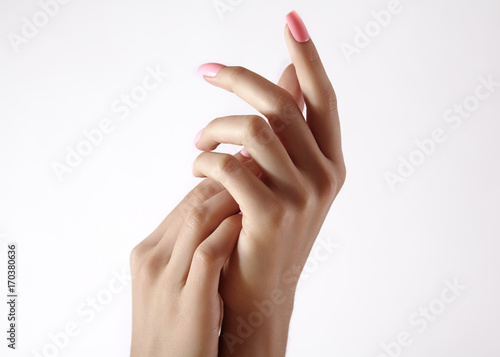 Beautiful woman's hands on light background. Care about hand. Tender palm. Natural manicure, clean skin. Pink nails photo