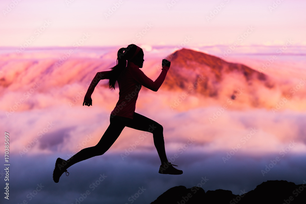 Trail runner nature landscape running woman silhouette on mountains background in cold weather with pink clouds at sunset. Amazing scenic view of peaks in altitude. Trail runner nature landscape running woman silhouette on mountains background in cold weather with pink clouds at sunset. Amazing scenic view of peaks in altitude.