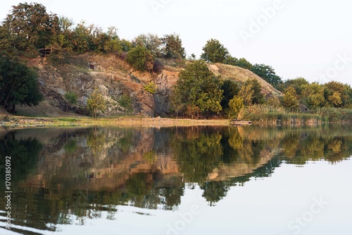 Beautiful riverfront scenery of calm water and part of forest 