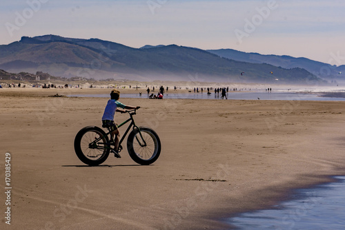 Boy riding fat wheel bike on the beach