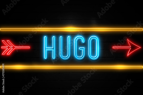 Hugo - fluorescent Neon Sign on brickwall Front view