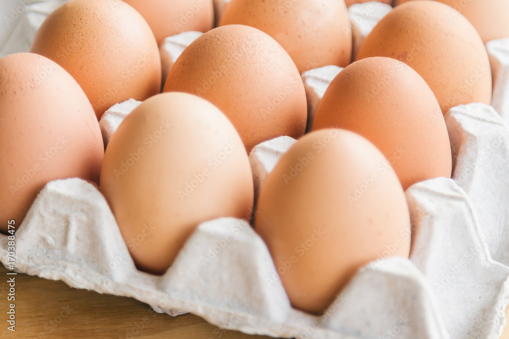 Fresh eggs in egg rack put on wood table. Prepare chicken eggs for cooking or bakery on rustic wood table. Close up with selcetive focus concept fresh eggs with copy space for background or wallpaper. Fresh eggs in egg rack put on wood table. Prepare chicken eggs for cooking or bakery on rustic wood table. Close up with selcetive focus concept fresh eggs with copy space for background or wallpaper.
