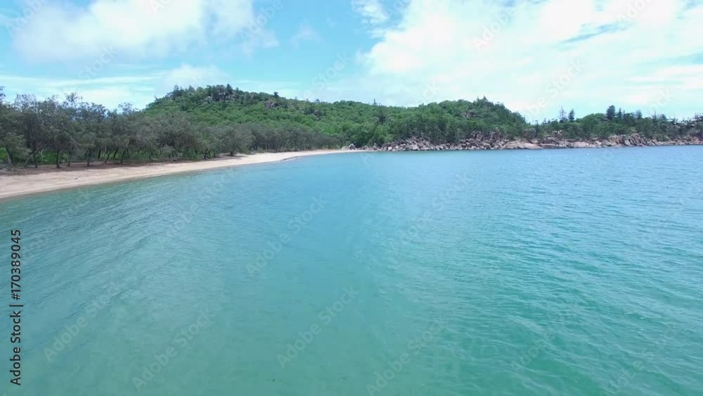 A wide shot of the ocean and shoreline showing forest trees A wide shot of the ocean and shoreline showing forest trees