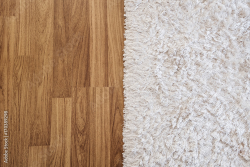 Close-up luxury white carpet on laminate wood floor in living room, interior decoration photo