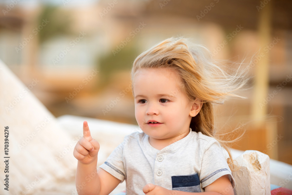 Fototapeta premium Boy child with cute smiling face pointing with pointer finger