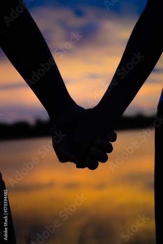  Couple holding hands a watching a beautiful sunset