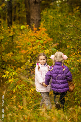 Cute little girls in the autumn forest