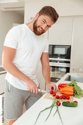 Vertical image of smiling bearded man with vegetable