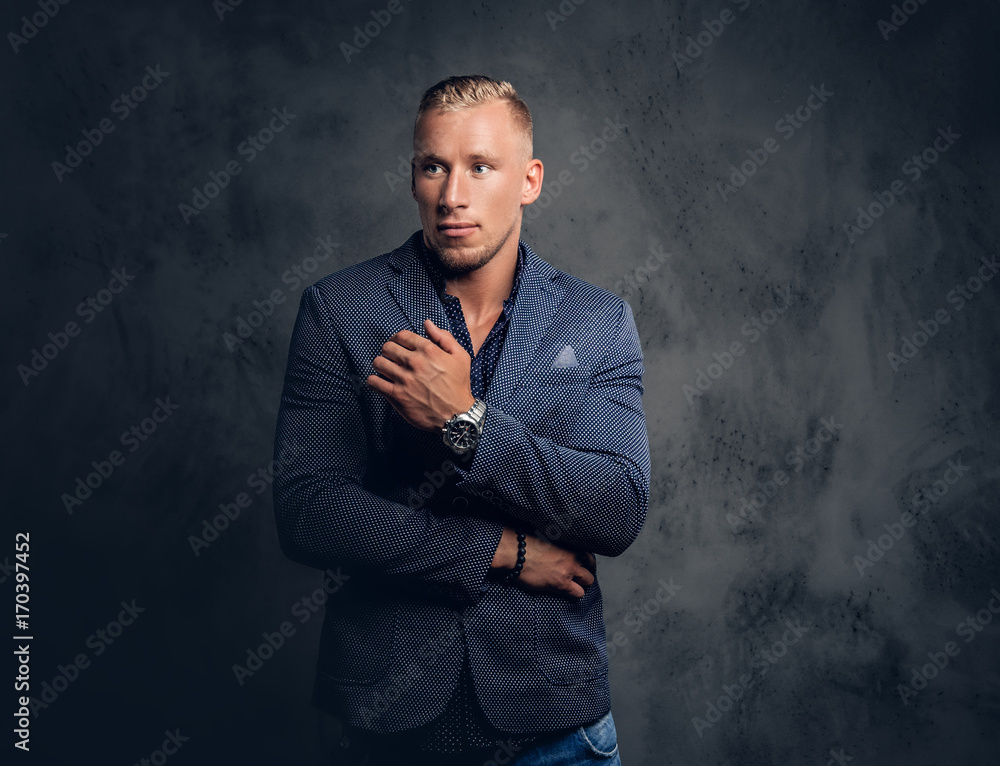 Studio portrait of a male dressed in a blue suit.