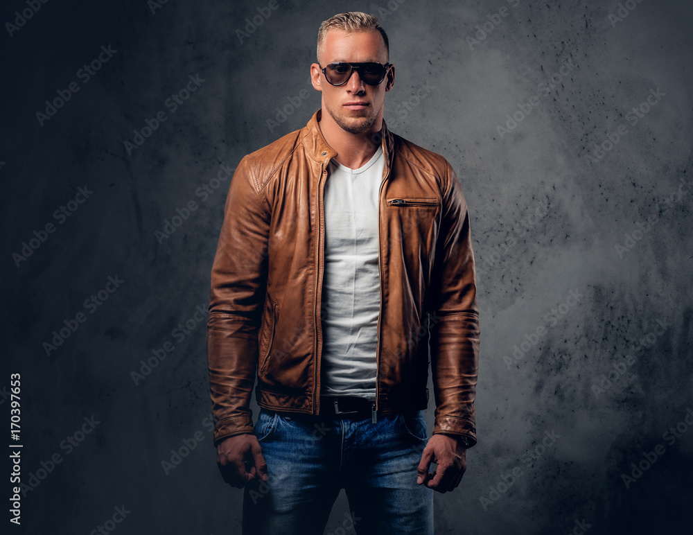 A man in sunglasses and brown leather jacket.