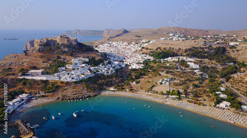 Aerial drone photo of famous beach of Lindos with turquoise waters and iconic ancient Acropolis - village of Lindos, Rodos island, Aegean, Dodecanese, Greece © aerial-drone