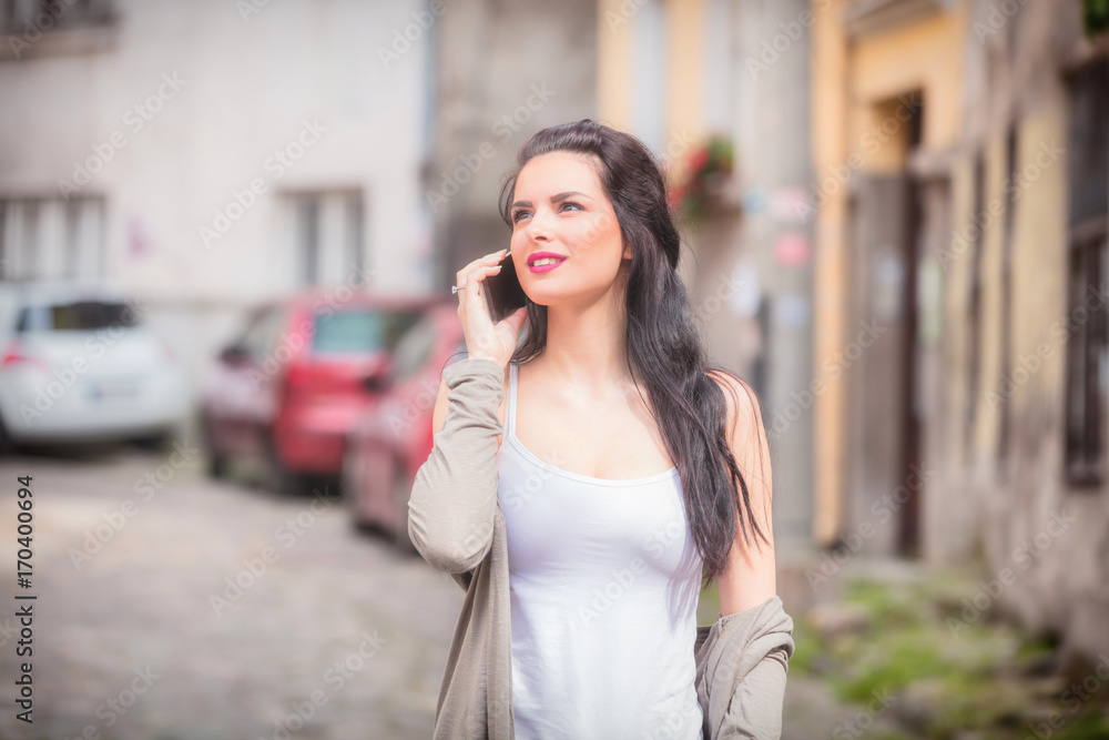 Cute girl using cellphone on the street. Cute girl using cellphone on the street.