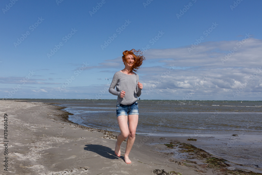 Frau läuft am Strand 