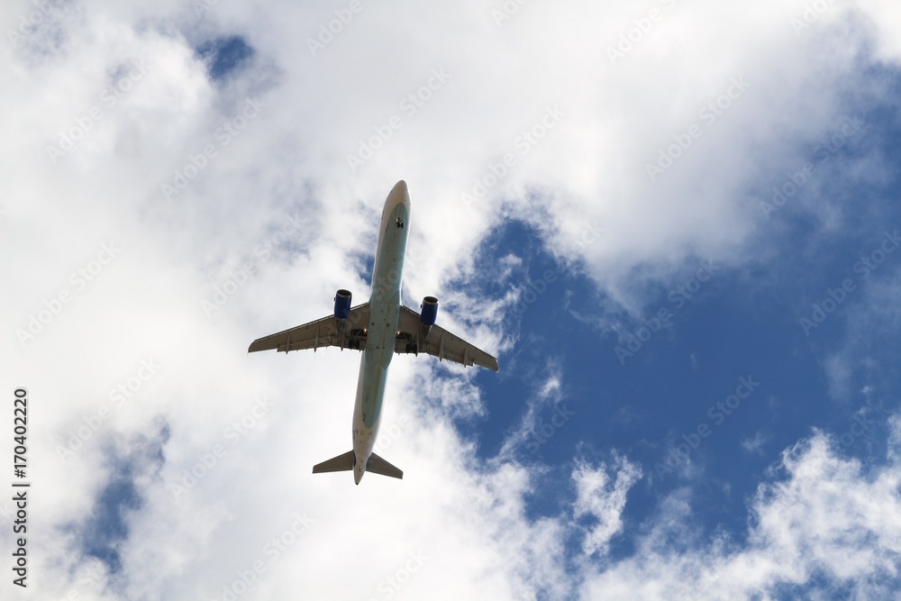 Naklejka premium Airplane on blue sky and white clouds background