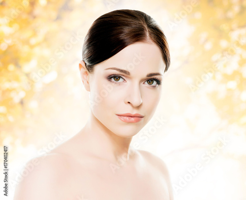Portrait of young, beautiful and healthy woman: over orange background. Healthcare, spa, makeup and face lifting concept.