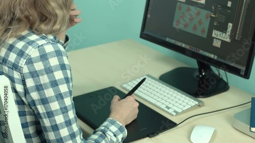 Girl designer working at computer using stylus and graphic tablet close-up 4k. photo