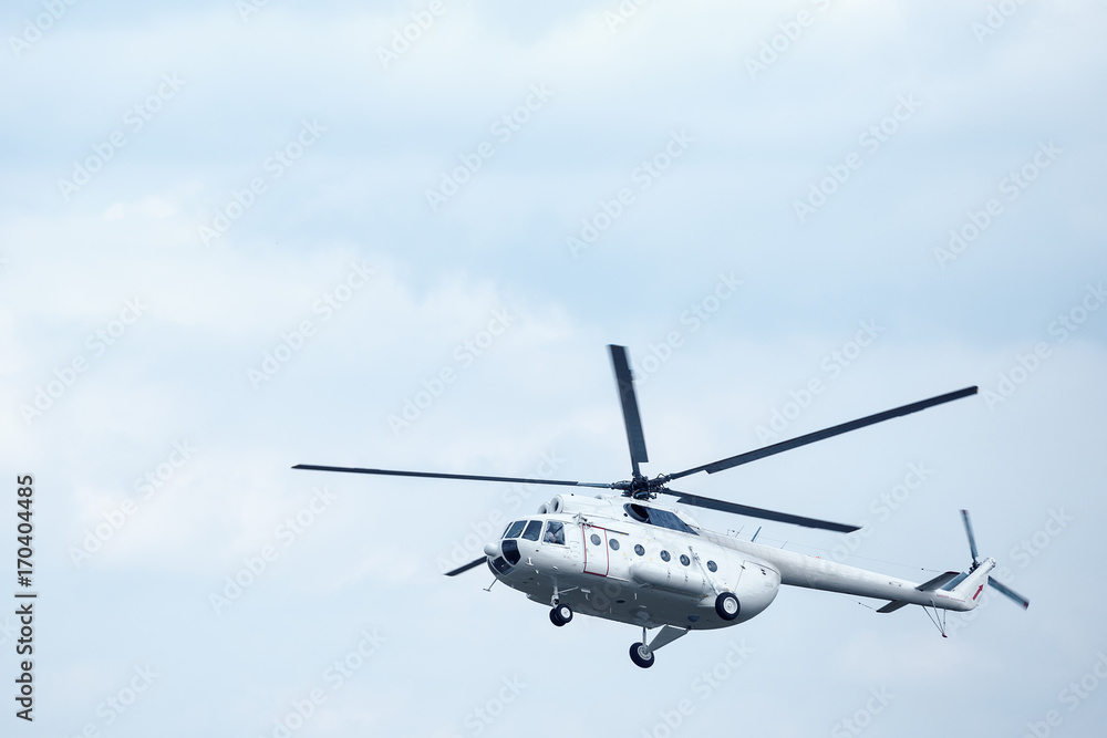 White helicopter in the blue sky