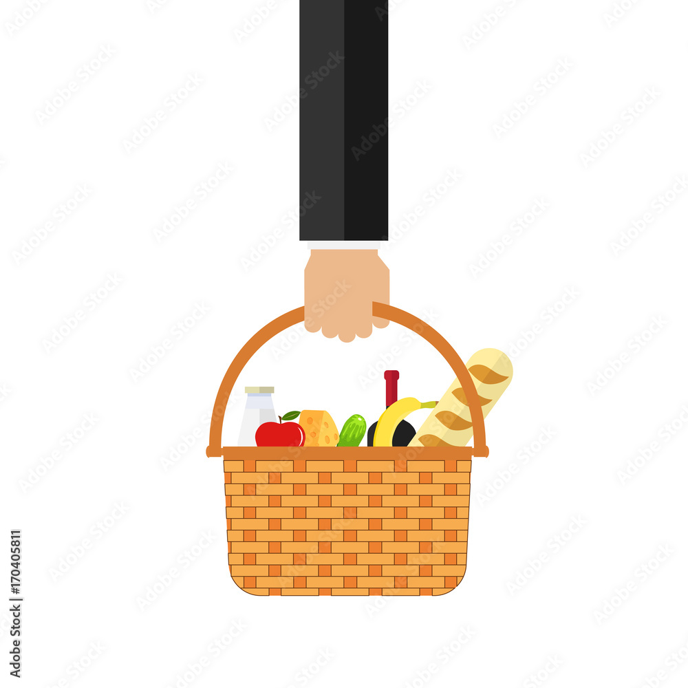 The hand holds a wicker basket with food. Basket with food in hand.