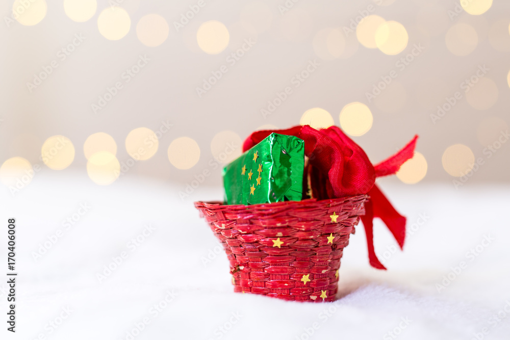 röd korg med grönt paket framför bokeh bakgrund Stock Photo | Adobe Stock