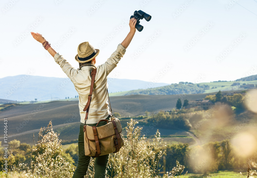 woman hiker hiking in Tuscany with binoculars rejoicing woman hiker hiking in Tuscany with binoculars rejoicing